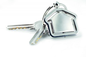 Two silver keys with metal house figure