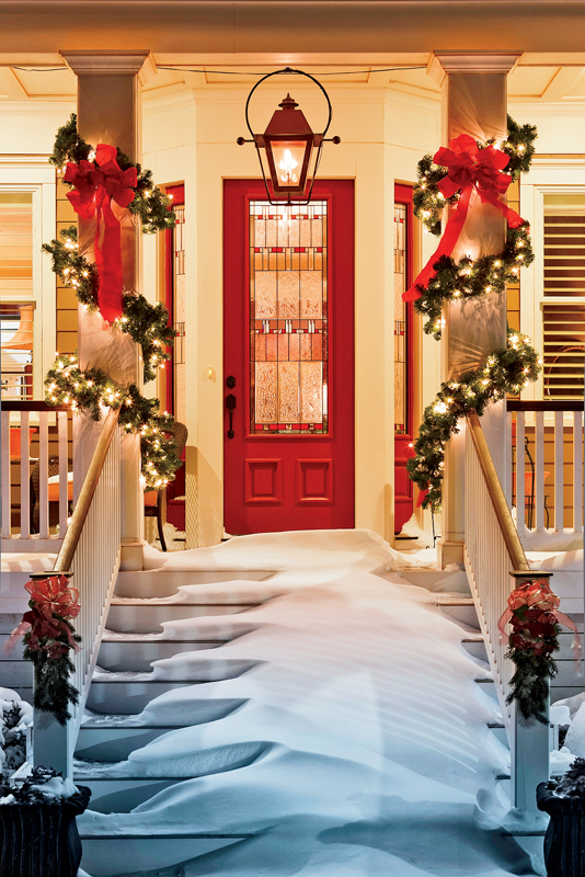 inviting doorway with snow on porch stairs and railing