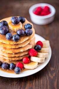 Delicious pile of hot homemade pancakes with fresh raspberries a