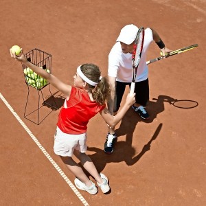 Coach with junior tennis player on tennis class