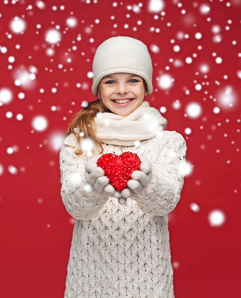 girl in winter clothes with small red heart