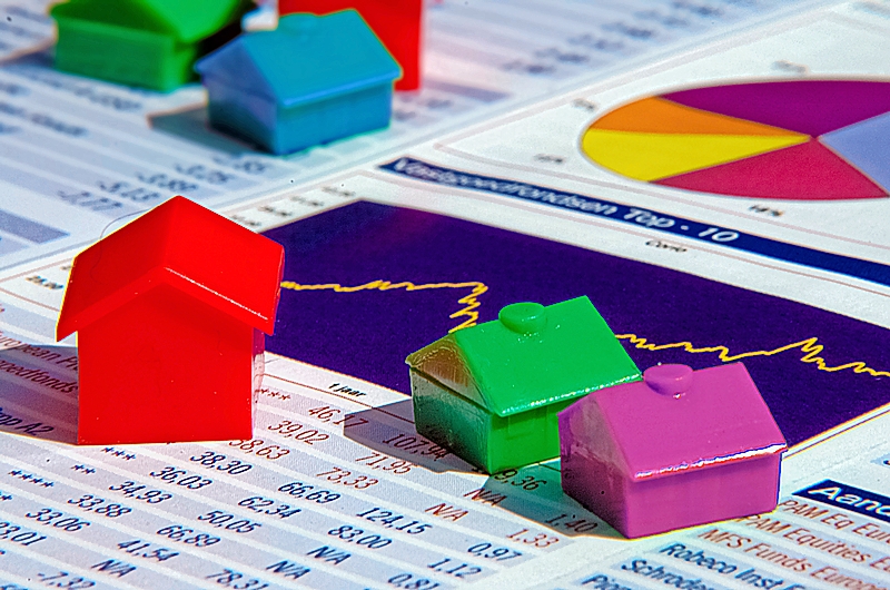 Colorful models of houses sitting on a real estate chart