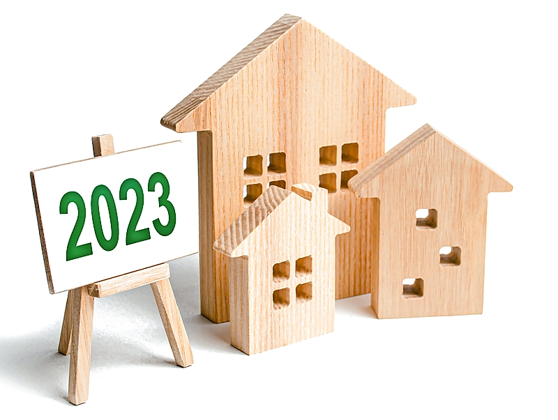 A 2023 sign next to wooden models of houses