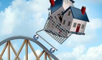 Falling home prices and declining real estate value illustrated as sold houses in a shopping cart going down a roller coaster