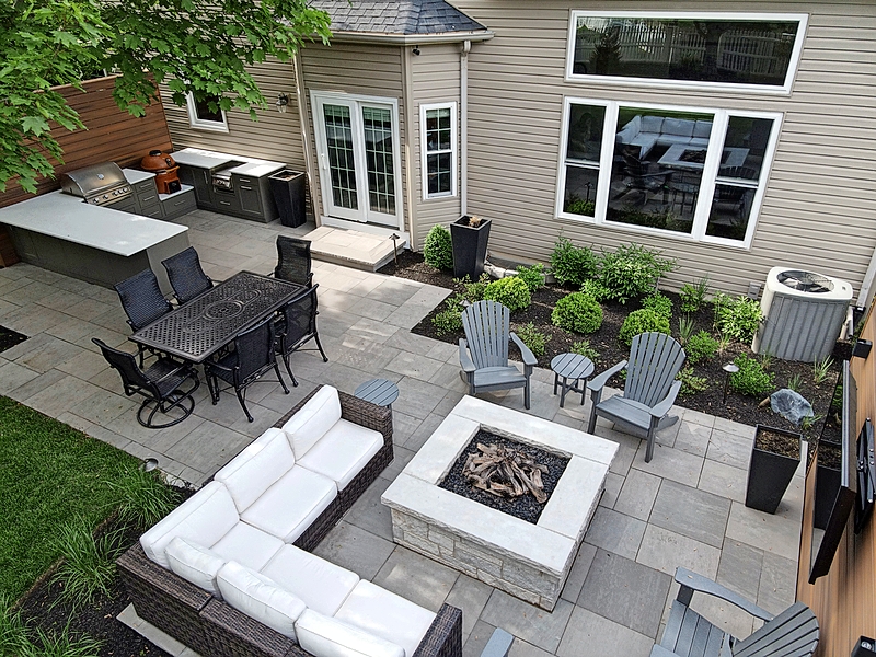Burkhart Outdoors constructed this massive, 1,800-square-foot limestone patio with multiple rooms on a sloping Naperville yard. A mix of open and covered spaces provide options for gathering outside in a variety of weather conditions.