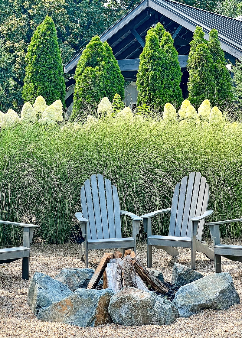 Western DuPage Landscaping used granite boulders and lava rock to create this wood-burning campfire area at a Naperville home. A gravel base and subsurface materials encourage water to drain quickly so the fire pit can be used even shortly after a rain.
