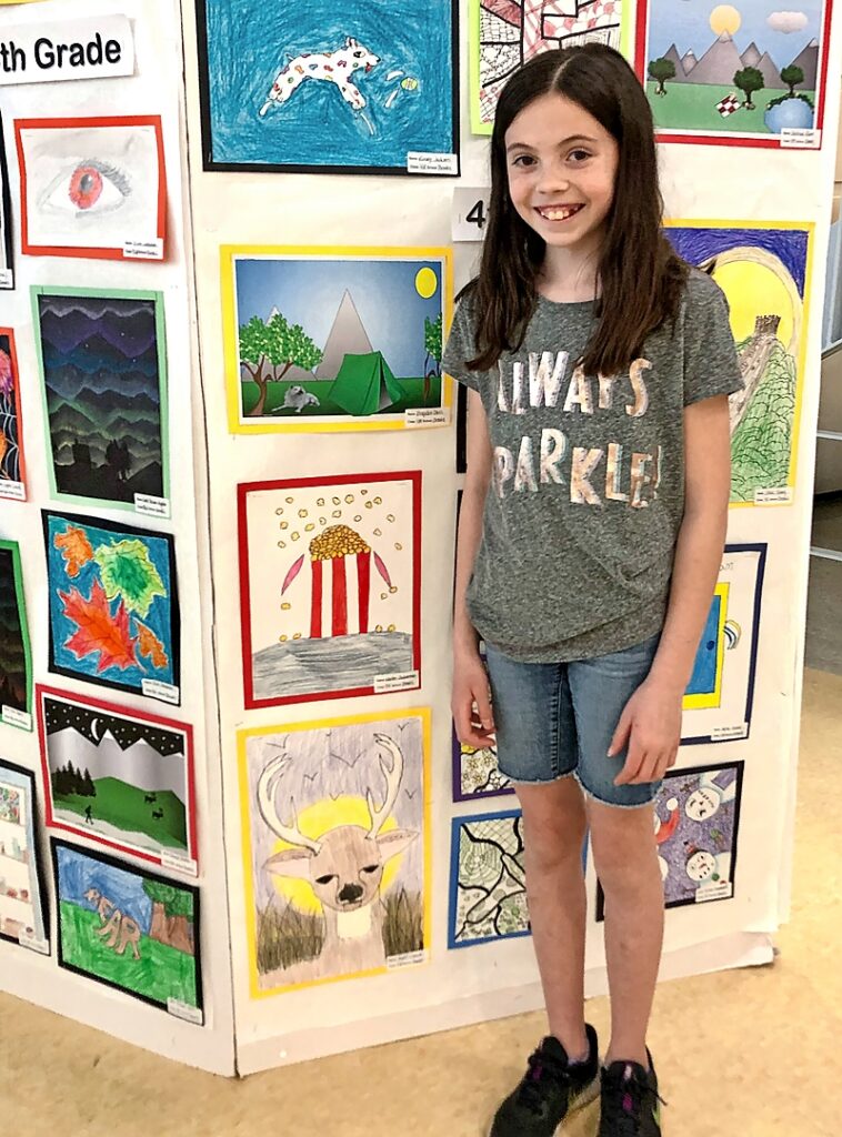 A young girl standing near artwork