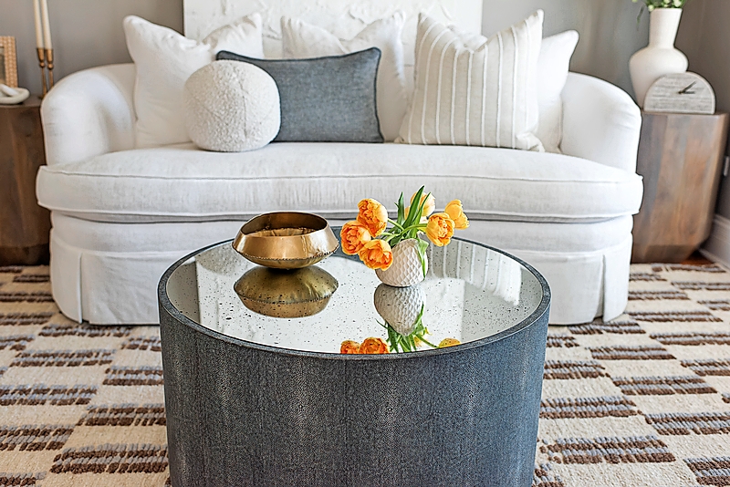 A coffee table and love seat living room set up designed by Ellce Home, Design Studio + Shop