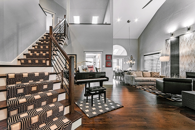 The original staircase led up to a loft area bordered by railings, with a view down to the first floor below. “It looked like a birdcage with all the balusters, so we put up a wall to give more privacy,” designer Bobbi Alderfer says. The original stair railing was replaced with simple newel posts and wrought-iron balusters. The geometric stair carpeting is by Milliken.
