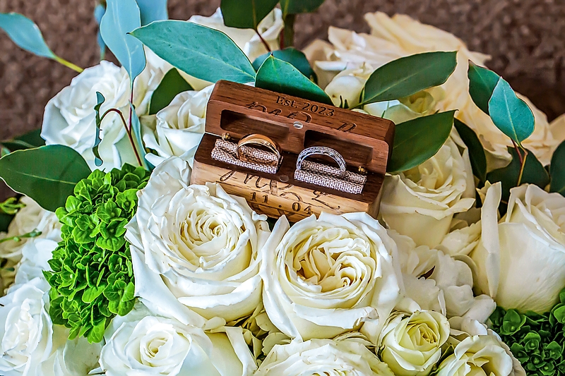 Wedding rings displayed among white roses