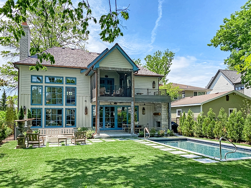 The backyard, patio, and pool of a two-story home