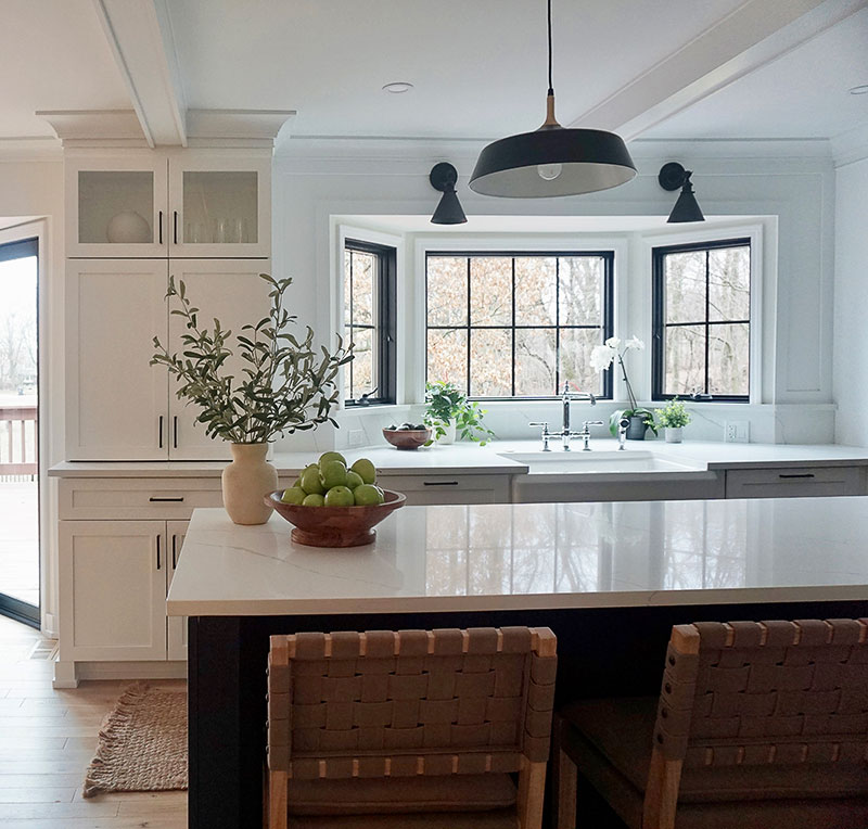 The original kitchen layout featured a dining nook in front of a large bay window that extended nearly to the floor. In Prignano’s new design, she reworked the window to be counter-height. “That way the sink could go there, and you have these beautiful views of the backyard and the wooded area behind the home,” she says. The countertops throughout are Q quartz in Calacatta from MSI Surfaces.