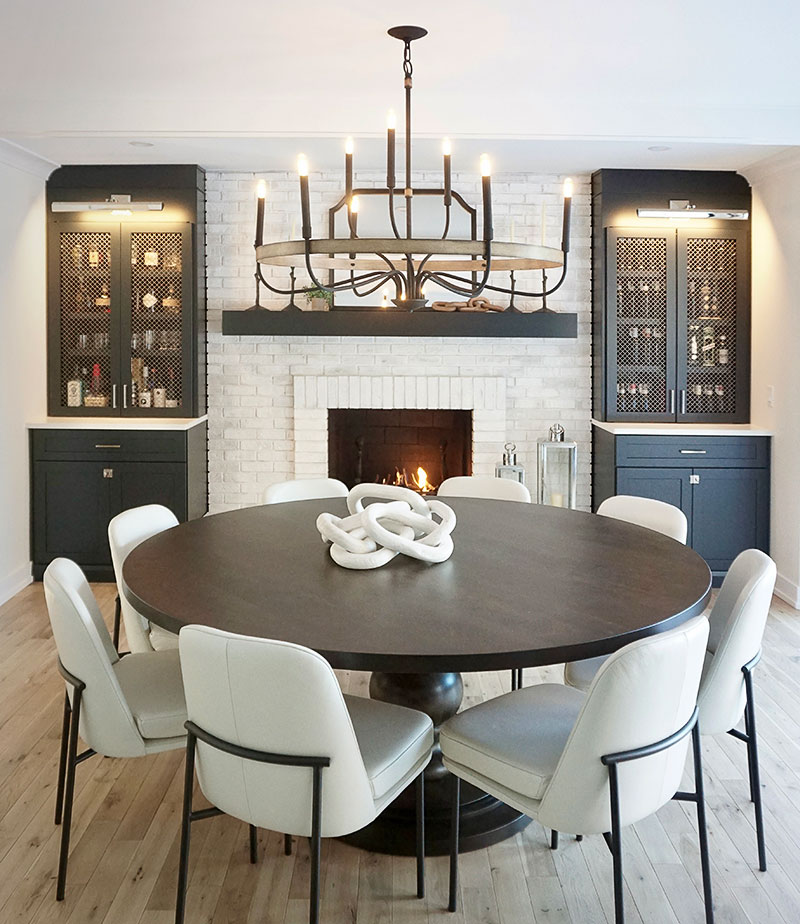 The new dining room features a custom-made round table from JN Woodworking in Hannibal, Missouri, paired with West Elm chairs. “The quality of this table was just gorgeous in person, and the dining chairs, we went with a white leather chair just to give a modern feel and contrast with the dark stain on the wood table,” Prignano says.
