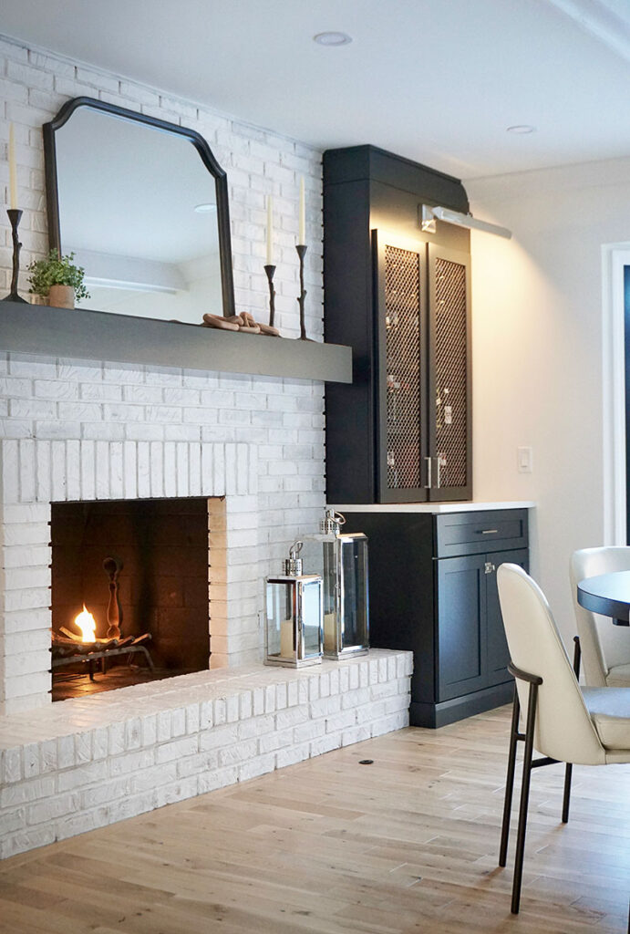 For a lighter, brighter look, the original dark brick fireplace in the dining room was whitewashed with a white limewash paint and a simple wooden mantel was added.