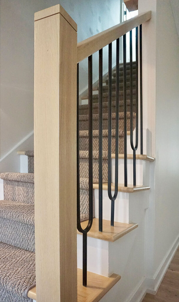 In the entryway, renovations included new stair treads, a carpet runner, and custom balusters by JPM Wood in Brooklyn, New York. “We mixed it up a little bit with these curvy iron balusters that really draw your eye,” Prignano says.