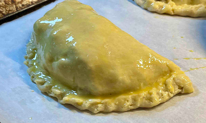 An uncooked pasty with egg wash