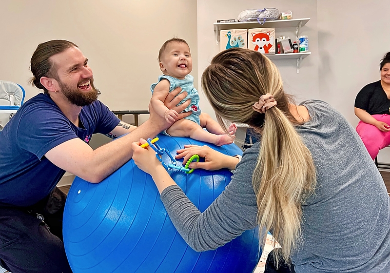 A man and woman playing with a baby