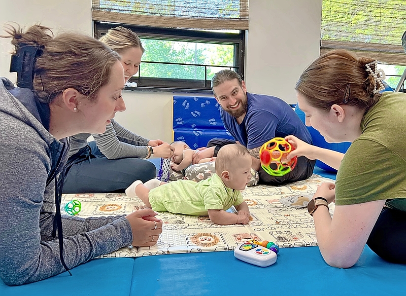 A team of pediatric therapists—including physical therapist Jacob Cetera (center)—works with infants at the NICU Aftercare Clinic at Hummingbird Pediatric Therapies.