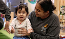 A small child smiling with a caregiver from Metropolitan Family Services DuPage