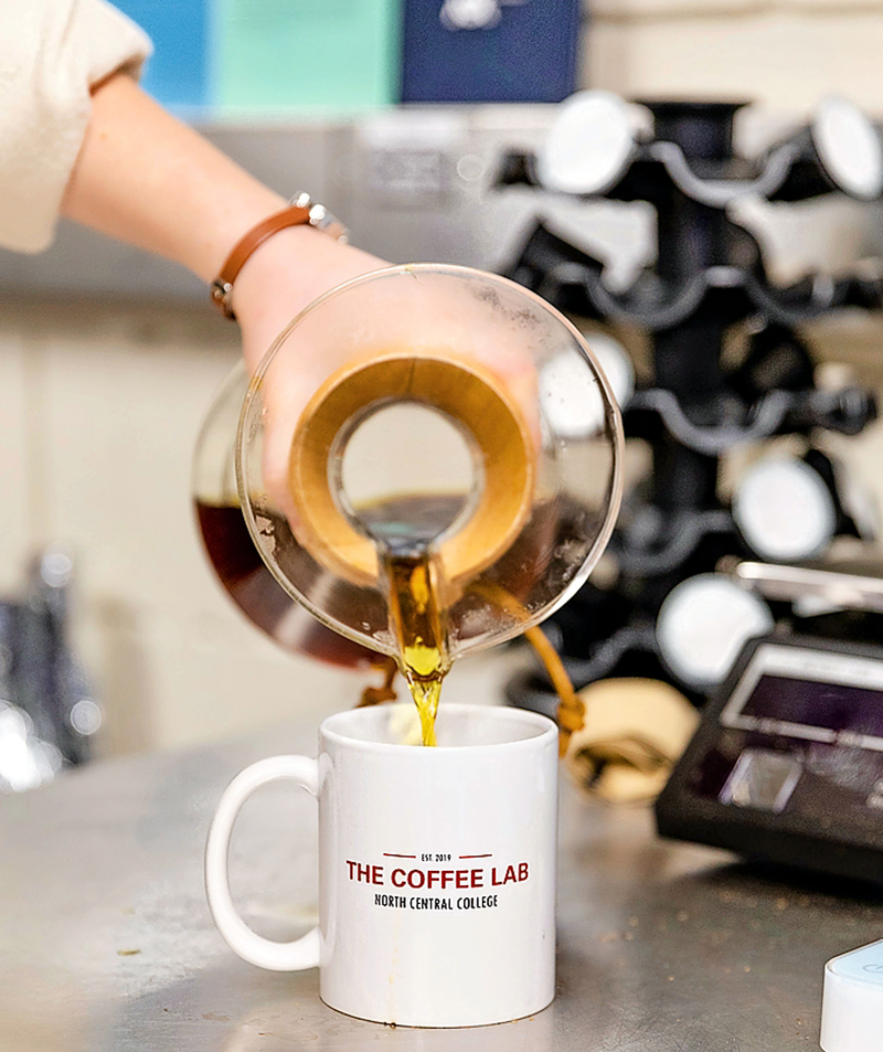 A student pouring coffee in the Coffee Lab at North Central College