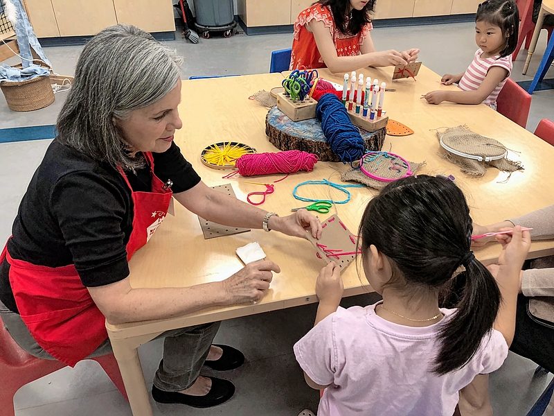 DuPage Children’s Museum volunteer Sue Kamm working with a young girl