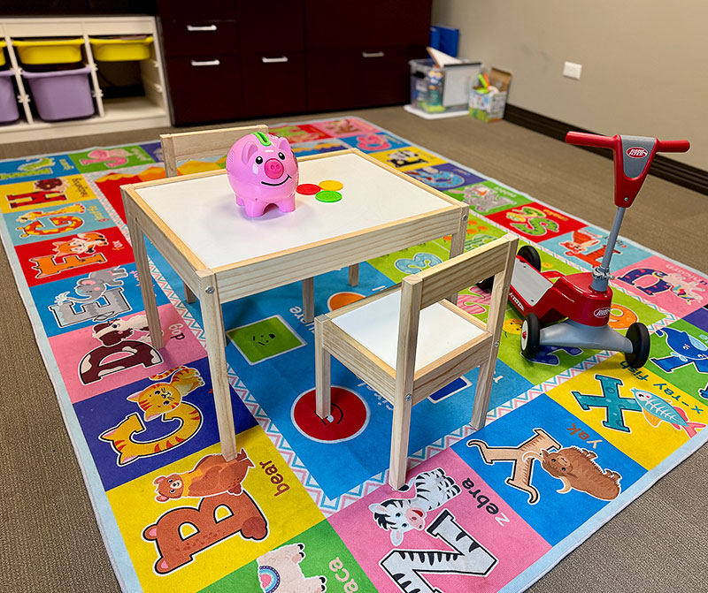 A child-size table and chair on a colorful mat