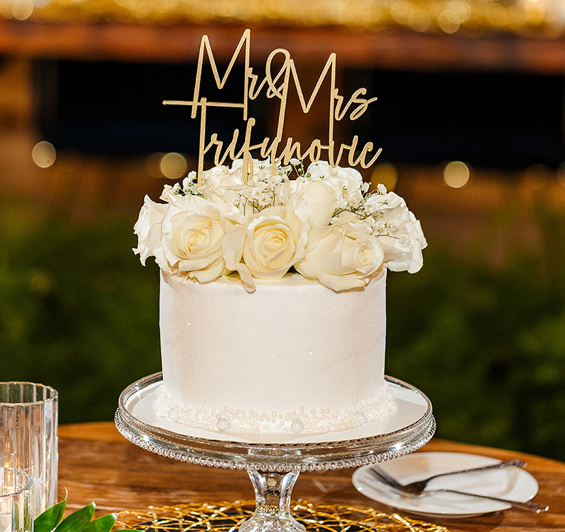 The wedding cake with a "Mr. & Mrs. Trifunovic" topper