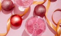 Pink, red, and gold holiday decorations on a pink background