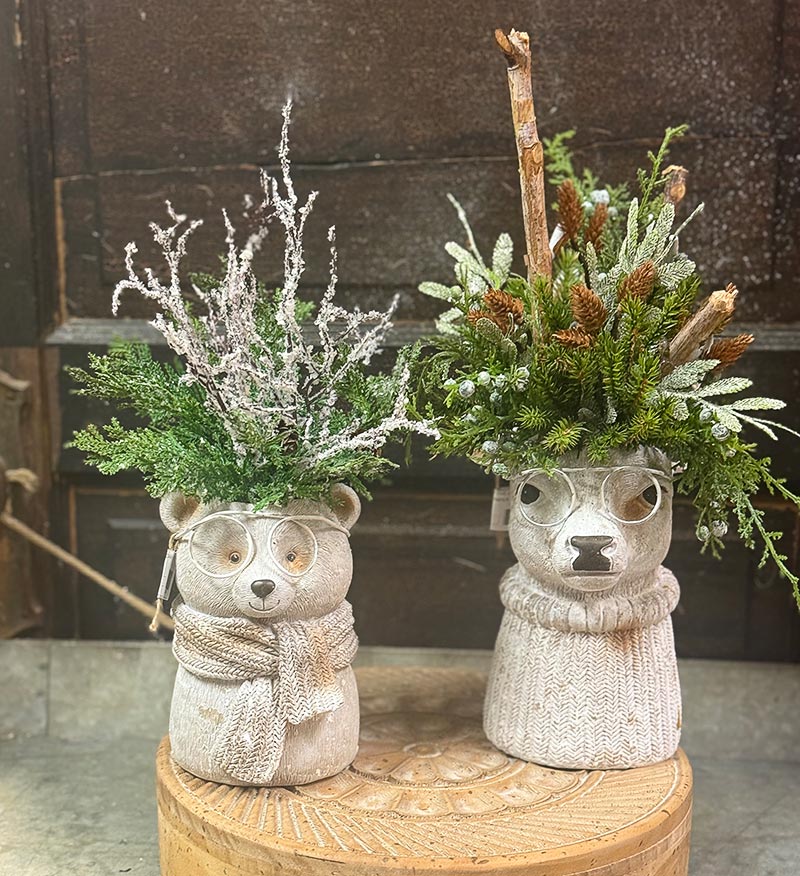 A bear vase and reindeer vase filled with winter foliage on display at Nona Jo’s