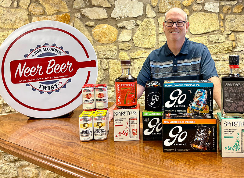 Jason Krapausky displaying various non-alcoholic drinks at Neer Beer N/A Bottle Shop