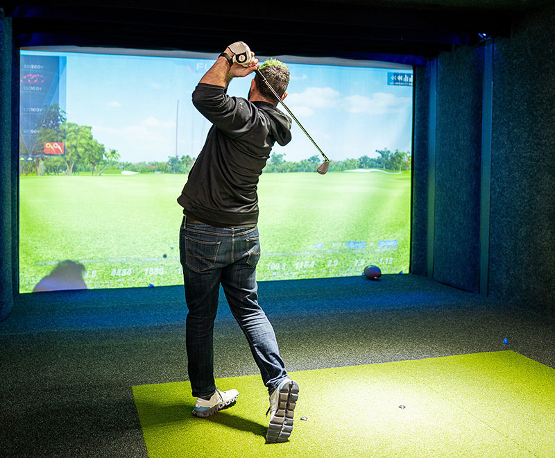 A man playing indoor golf at Lucky Swingz