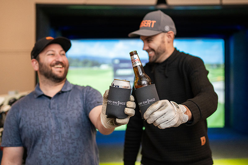 Two men toasting beers at Lucky Swingz