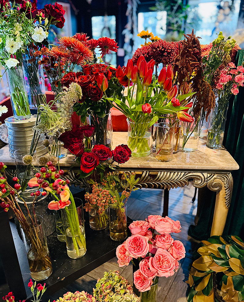 Flower arrangements displayed on tables and shelves at 6th and Foster
