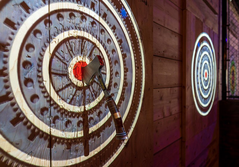 An axe in the center of a wall target at Legendary Escape Rooms & Axe Throwing