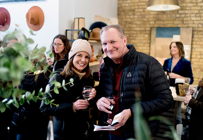 A couple in winter clothes posing for a photo at Downtown Wheaton Association’s Winter Wine + Cheese Walk
