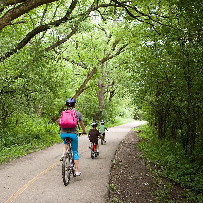 A woman and two small children biking on Salt Creek Trail