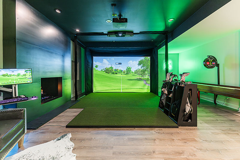 The golf simulator and shuffleboard table (complete with Michigan State wall sign) are major attractions in the Novys’ basement. Designer Dana Silver reimagined the traditional brick fireplace with a sleek new surround of hot-rolled steel.