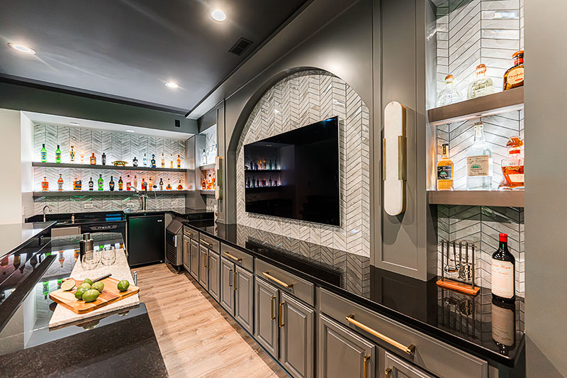 One quirk that Silver had to contend with was a rectangular cutout in the granite countertop. “The previous owners had a reach-in cooler and when they replaced it with under-cabinet refrigerators, it left a void,” Silver says. “We decided to replace it with an accent stone piece in a light color that they can use like a cutting board.”