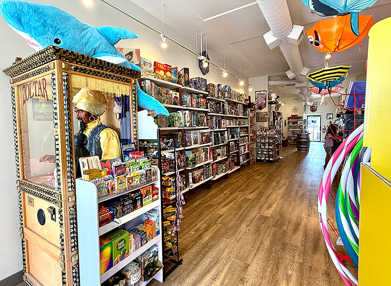 A Zoltar machine, plush shark, and a variety of cards and games at Treasures