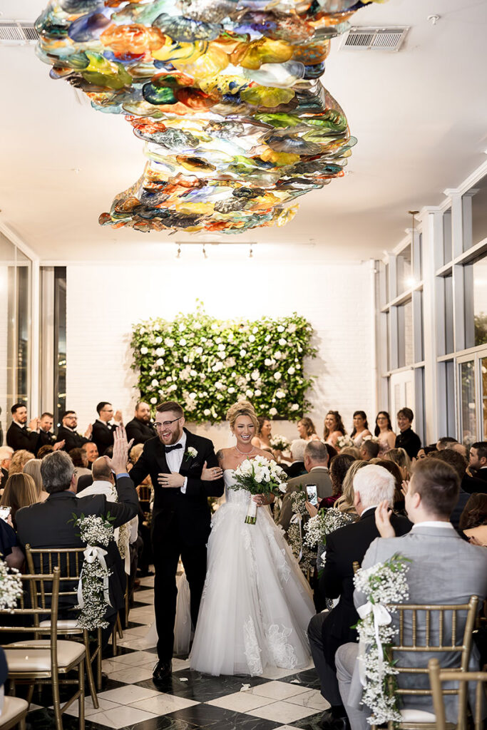 Tommy Burmeister and Danielle Johnson walking down the aisle at their wedding.