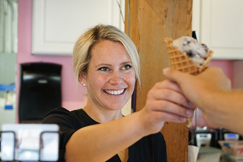 A server handing a customer a cone at Kimmer’s Ice Cream