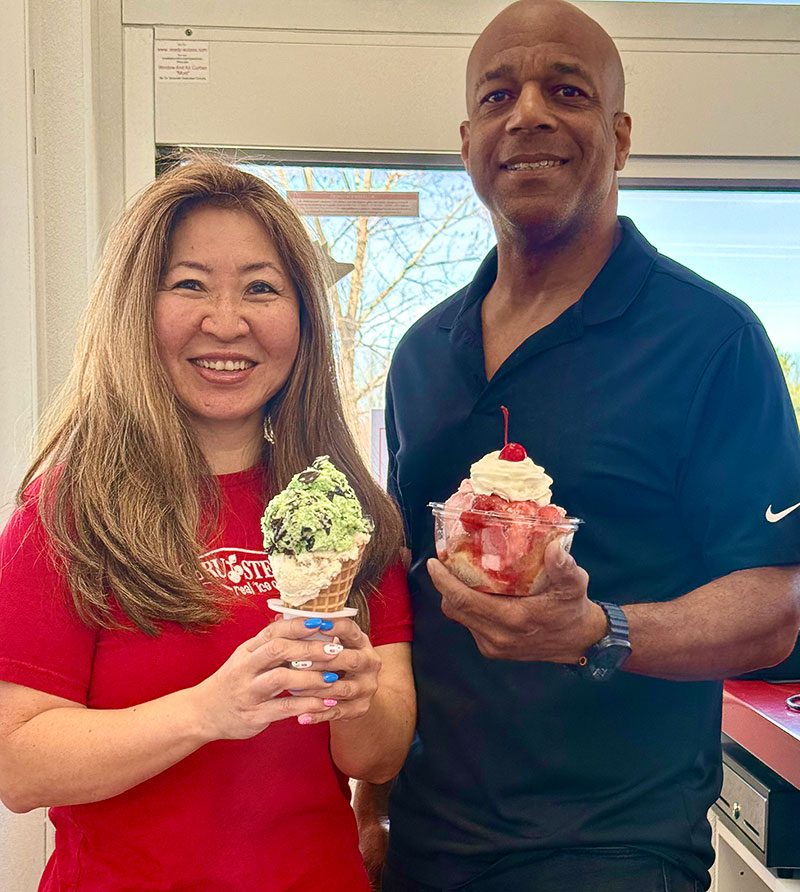 A woman holding an ice cream cone and a man holding a sundae at Bruster’s Real Ice Cream